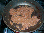 フライパンで合びき肉とみじん切りにした玉ねぎを炒める